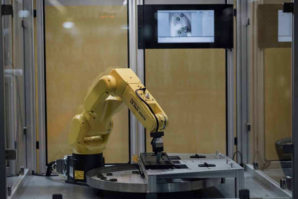 Braço robótico operando um componente em laboratório de tecnologia
